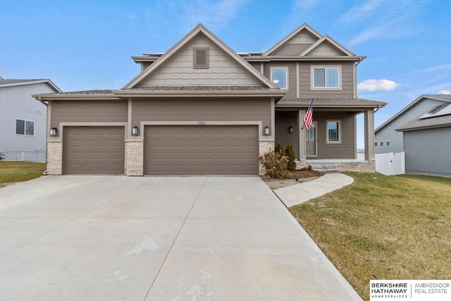 craftsman-style home with covered porch, a garage, and a front yard