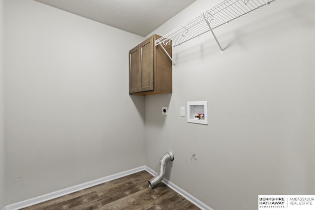 laundry area featuring cabinets, hookup for a washing machine, dark hardwood / wood-style floors, a textured ceiling, and hookup for an electric dryer