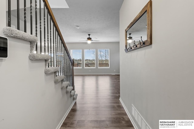 hallway with dark hardwood / wood-style flooring and a textured ceiling