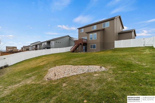 back of property with a lawn and a wooden deck