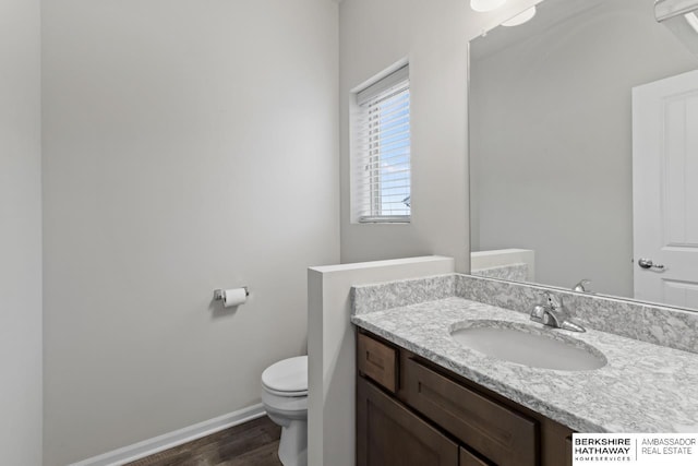 bathroom with hardwood / wood-style floors, vanity, and toilet