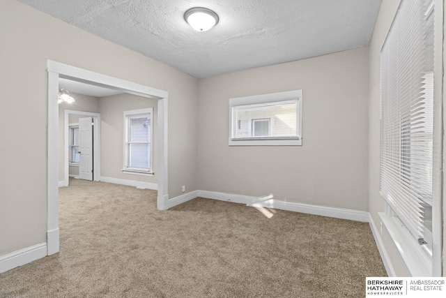 unfurnished bedroom with light colored carpet and a textured ceiling