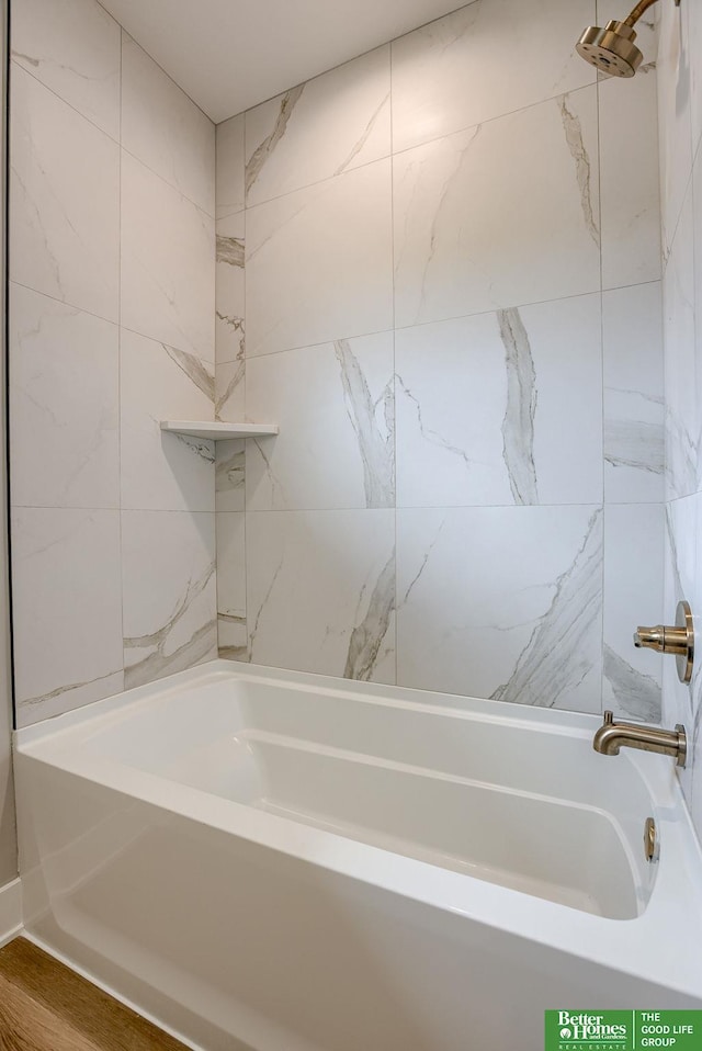 bathroom with hardwood / wood-style floors and bathing tub / shower combination