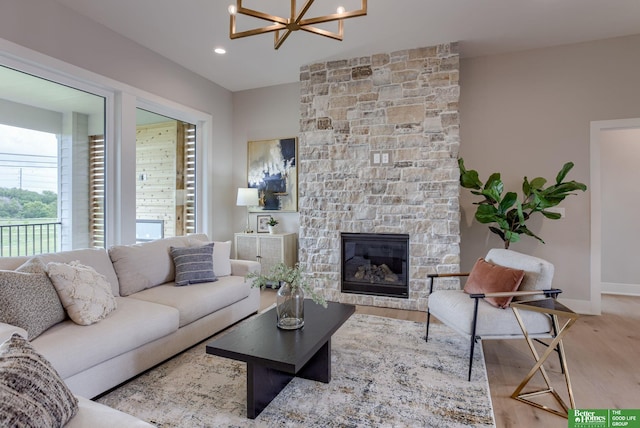 living room with a fireplace, hardwood / wood-style floors, and a notable chandelier