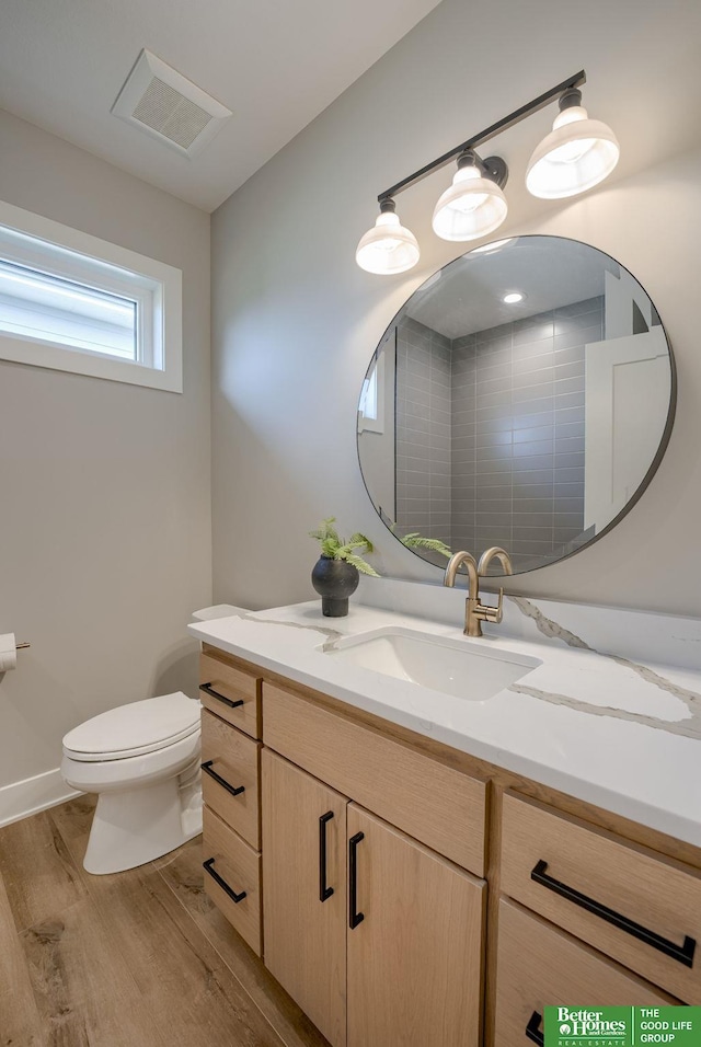 bathroom with toilet, vanity, and hardwood / wood-style flooring