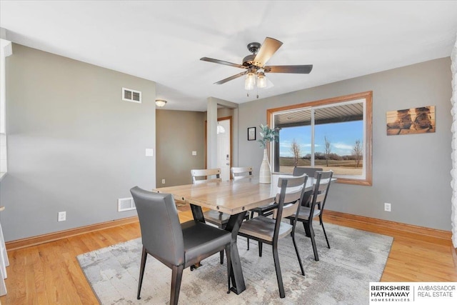 dining area with light wood-type flooring and ceiling fan