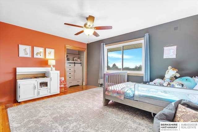 bedroom featuring ceiling fan, a closet, and light hardwood / wood-style floors