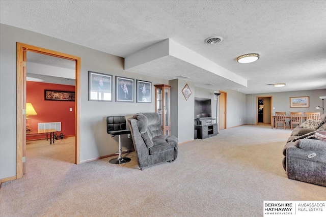 carpeted living room with a textured ceiling