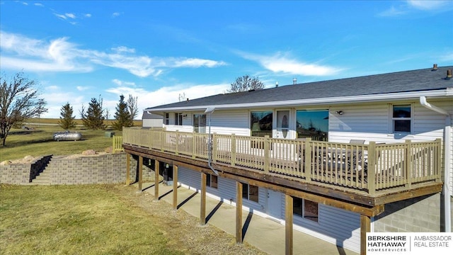 rear view of property with a lawn and a wooden deck