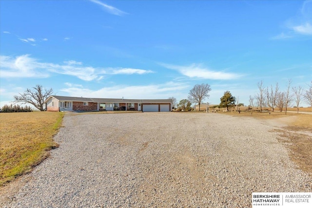 ranch-style home with a rural view and a garage