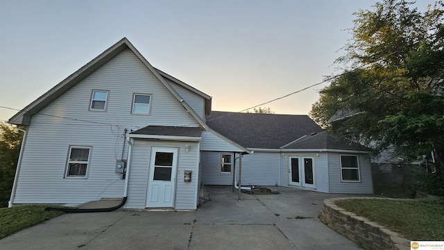 back house at dusk with a patio