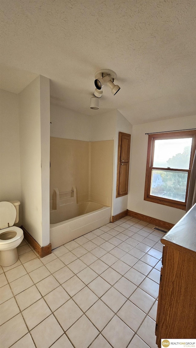 bathroom featuring bathtub / shower combination, a textured ceiling, tile patterned flooring, toilet, and lofted ceiling