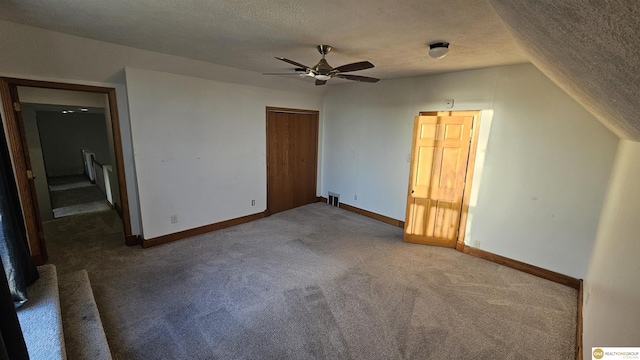 unfurnished bedroom featuring carpet, a textured ceiling, ceiling fan, a closet, and lofted ceiling