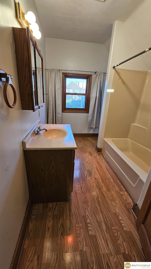 bathroom with shower / bathtub combination with curtain, vanity, and hardwood / wood-style flooring