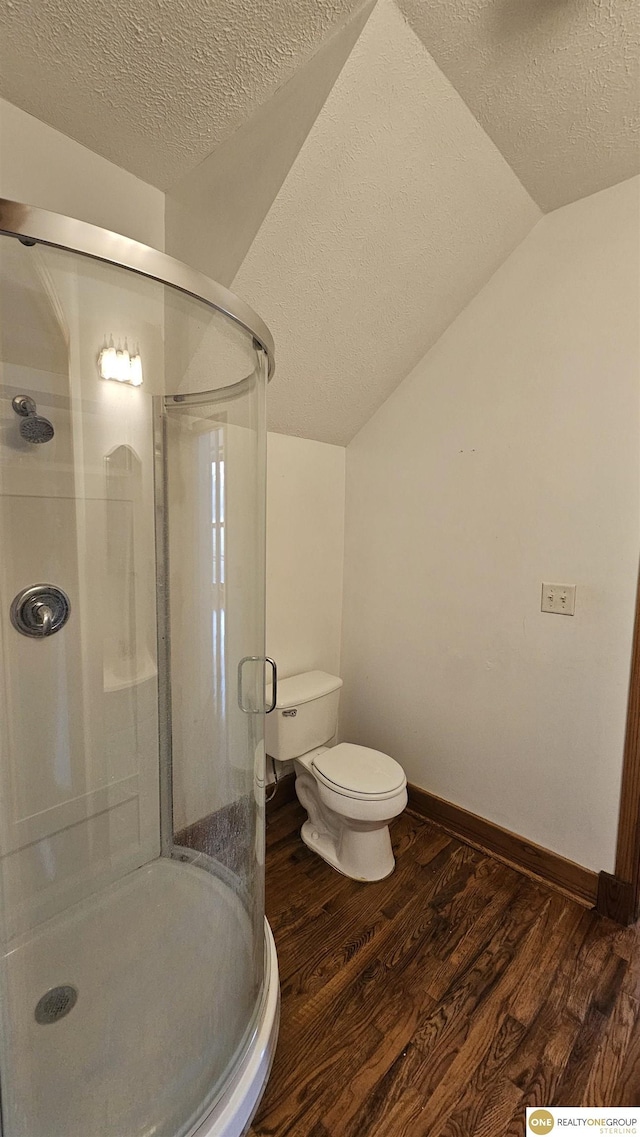 bathroom featuring a textured ceiling, hardwood / wood-style flooring, an enclosed shower, and lofted ceiling