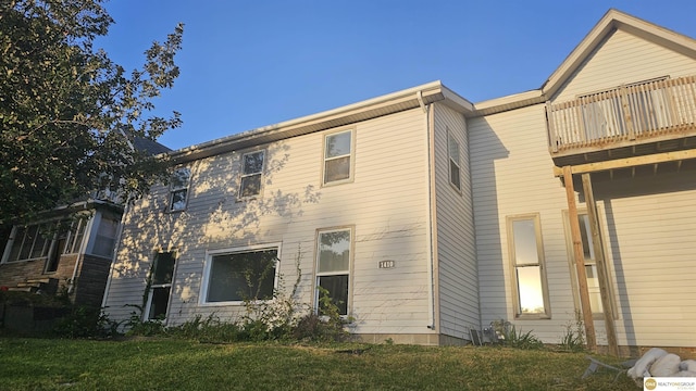 back of property featuring a yard and a balcony