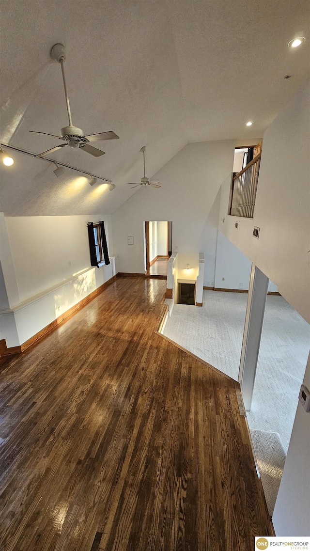 additional living space with dark hardwood / wood-style floors, ceiling fan, lofted ceiling, and a textured ceiling