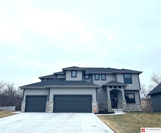 prairie-style home featuring a garage and a front lawn