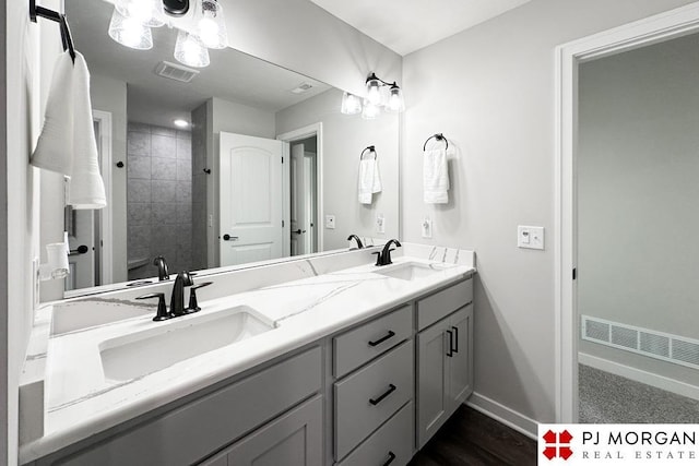 bathroom featuring a tile shower and vanity