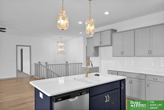 kitchen featuring dishwasher, sink, an island with sink, light hardwood / wood-style floors, and pendant lighting