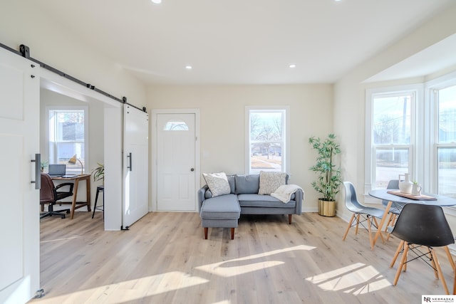 interior space with a barn door and light hardwood / wood-style floors