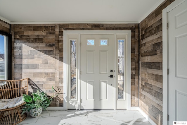 entrance foyer featuring crown molding and wooden walls