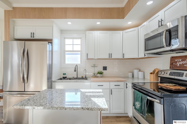 kitchen featuring light stone counters, sink, white cabinets, and stainless steel appliances