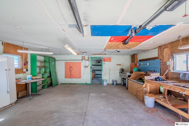 garage with a workshop area and white refrigerator