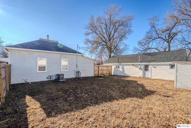 back of property featuring central AC and a lawn