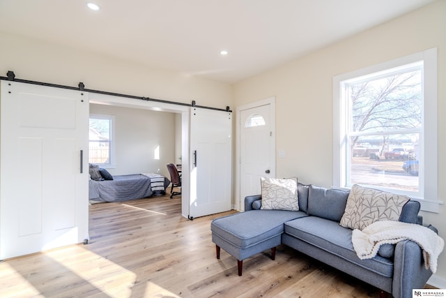 living room featuring a barn door and light hardwood / wood-style floors