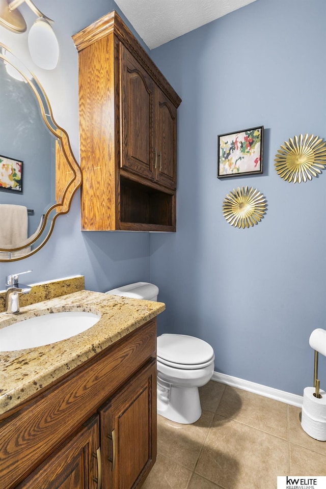 bathroom with tile patterned floors, vanity, and toilet