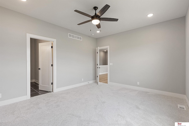 unfurnished bedroom featuring dark colored carpet and ceiling fan