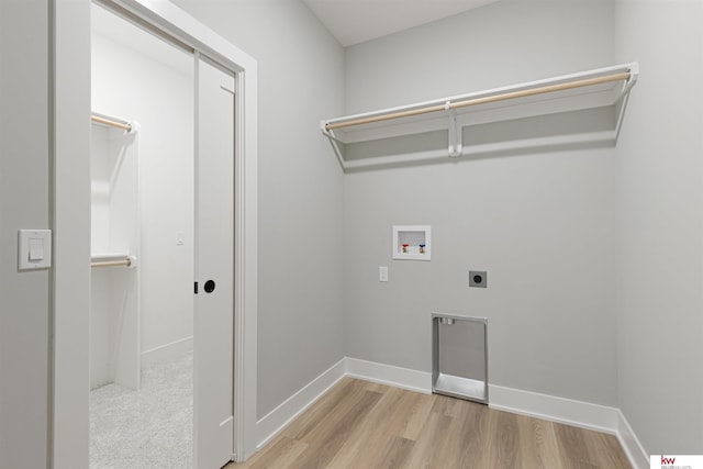 washroom with hookup for an electric dryer, washer hookup, and light wood-type flooring