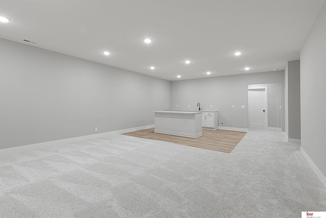 interior space featuring light colored carpet and sink