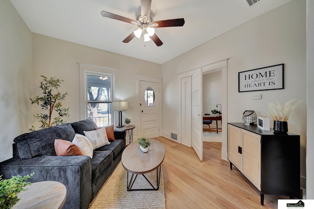 living room featuring light hardwood / wood-style flooring and ceiling fan