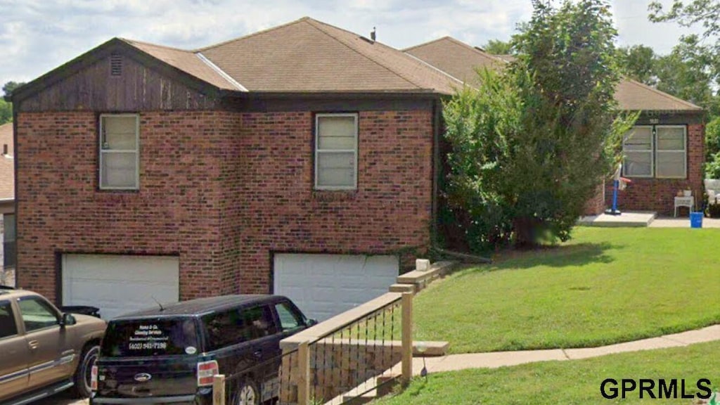 view of front of property with a front yard and a garage