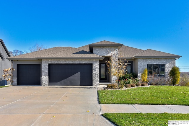 prairie-style house featuring a garage and a front lawn