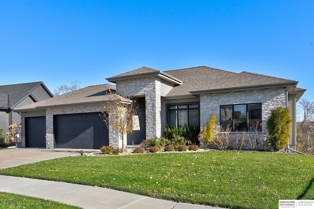 prairie-style home featuring a front lawn and a garage