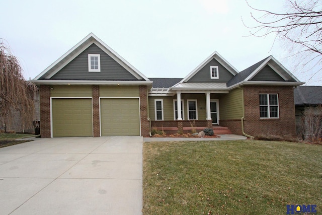 craftsman-style house with covered porch, a garage, and a front yard