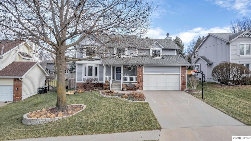 view of front of house with covered porch, a garage, and a front lawn