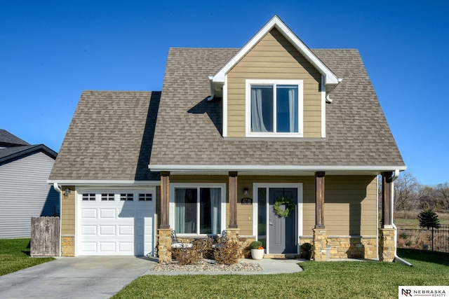 view of front of property featuring a porch, a front lawn, and a garage