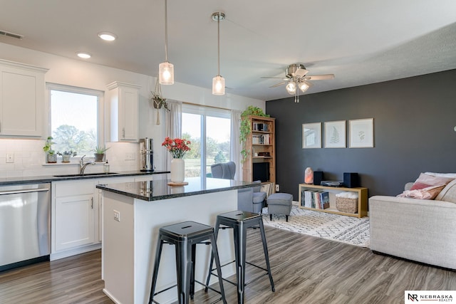 kitchen featuring sink, white cabinetry, dishwasher, and tasteful backsplash