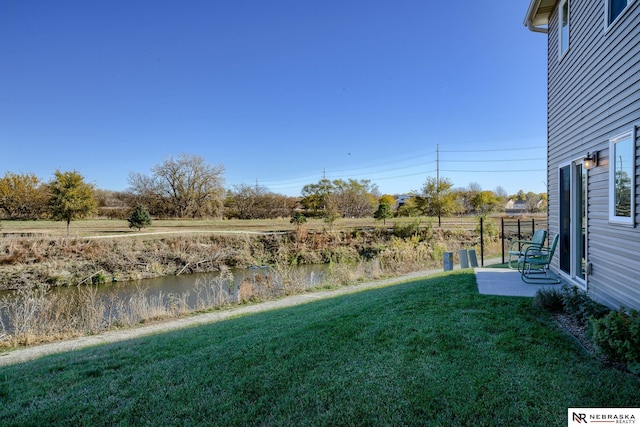 view of yard with a patio and a water view