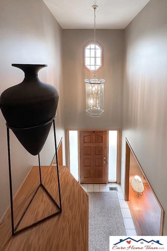 tiled foyer with a chandelier