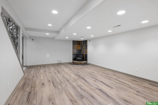 unfurnished living room with a wood stove and light hardwood / wood-style flooring