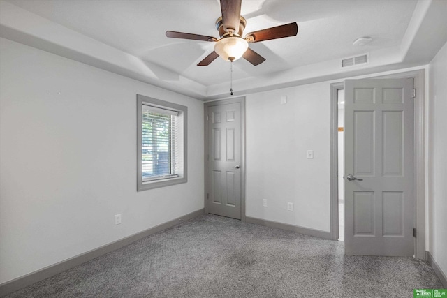 empty room with a tray ceiling and ceiling fan