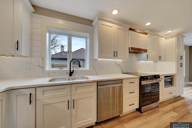 kitchen featuring white cabinets, sink, decorative backsplash, appliances with stainless steel finishes, and light hardwood / wood-style floors