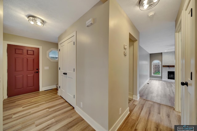 corridor featuring light hardwood / wood-style floors and a textured ceiling