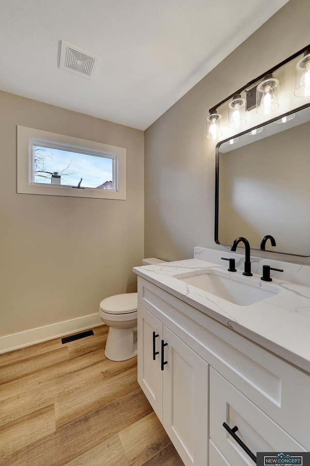 bathroom featuring vanity, hardwood / wood-style flooring, and toilet