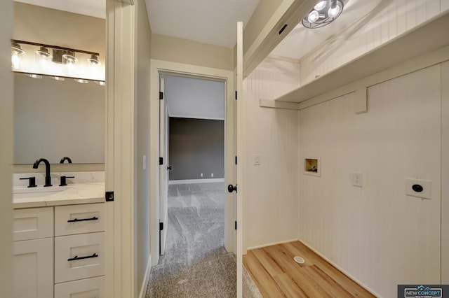 laundry area featuring sink, hookup for a washing machine, light colored carpet, and hookup for an electric dryer